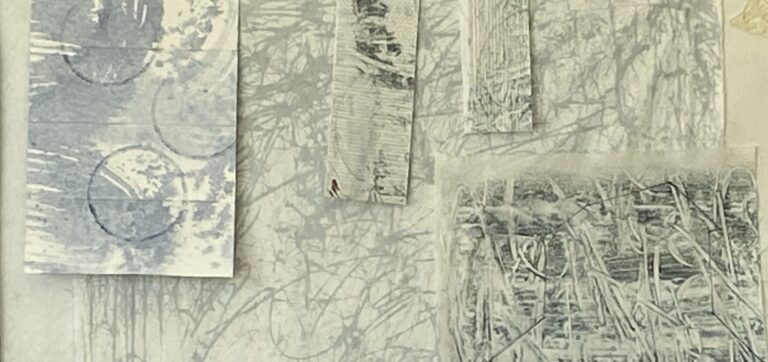 an image showing some pieces of fabric painted with mark making in soft gray blues and grays