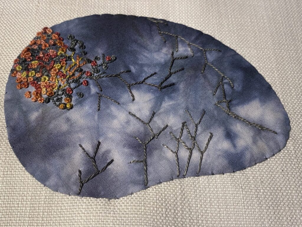 Gray rock embellished with colonial knots and fly stitch