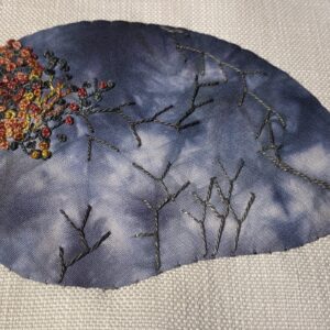 Gray rock embellished with colonial knots and fly stitch