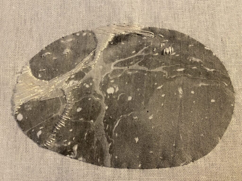 Embellished rock - gray with white stitching following the lines of the fabric