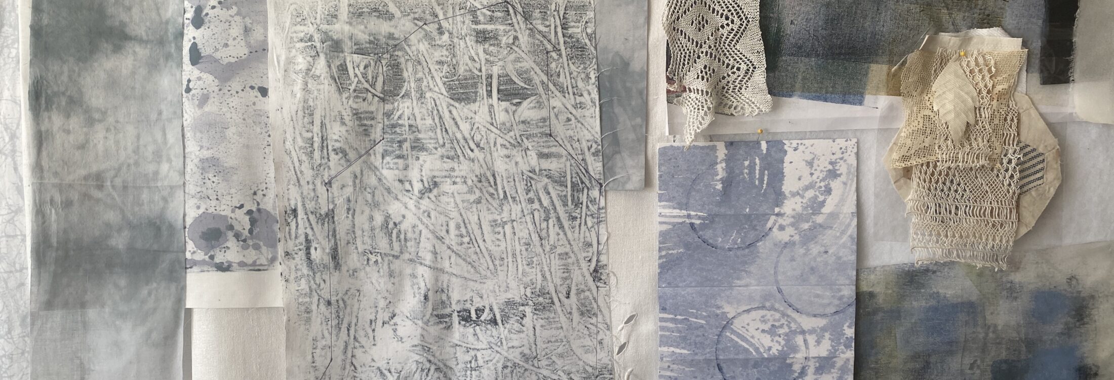 a shot of my design wall in my upstairs studio showing different painted and printed fabrics and bits of old lace - in preparation for new work