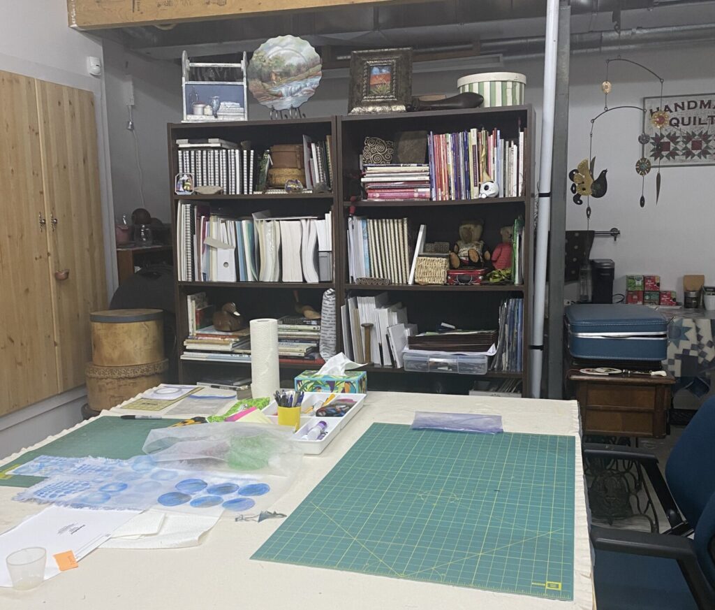 a shot of my basement studio showing the two bookcase units that act as a divider between the tables and the sinks