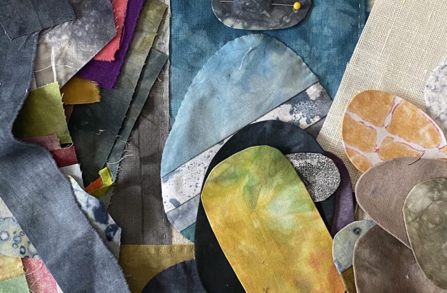 an image showing a stack of scraps of fabric on a piece ini progress with textile rocks on top