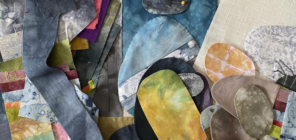 an image showing a pile of scraps of fabric on the left with some sewn rocks on the right in all colours and shapes ready to be stitched onto a background and made into work