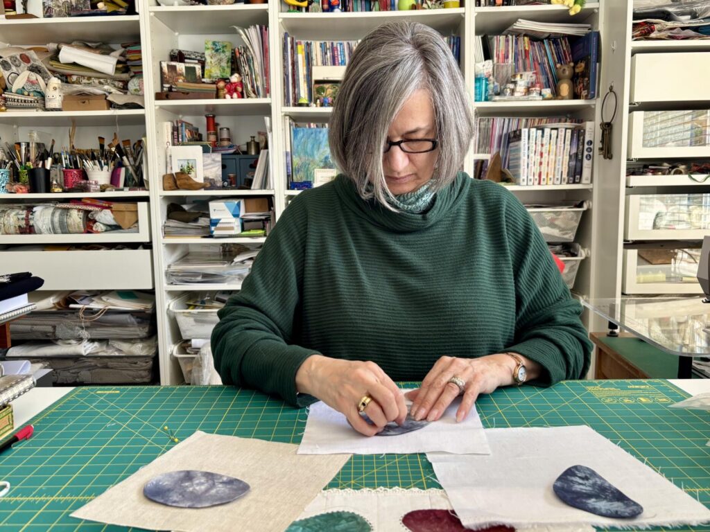 an image showing me working in my studio and stitching some of my rocks pebbles and stones 