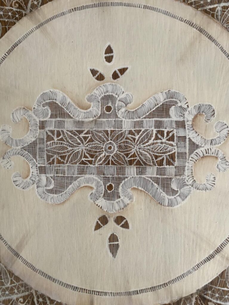 an image showing a vintage chair with a lace "doily" painted on the seat. Inspired by Italian lace - close up - detail