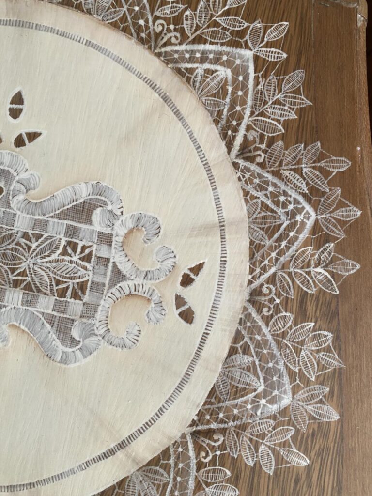 an image showing a vintage chair with a lace "doily" painted on the seat. Inspired by Italian lace - close up - detail