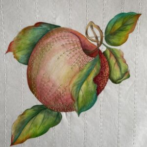 an image showing an apple design on fabric painted with Inktense pencils and embellished with threads